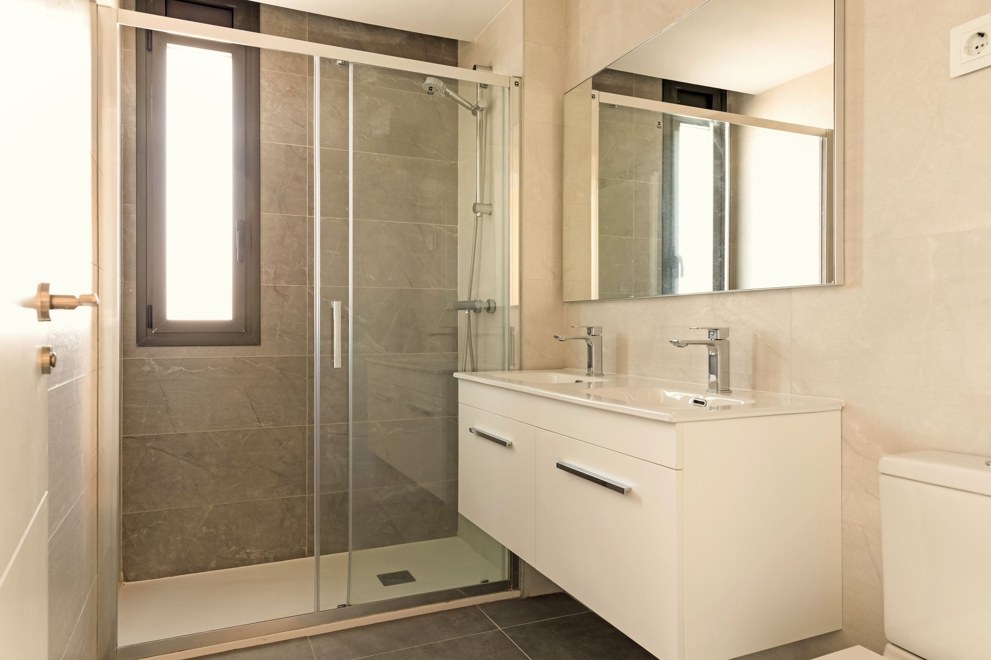 Lavabo doble y ducha amplia.